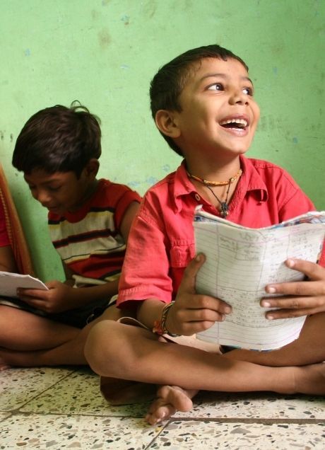 Two boys happily reading a book, supported by Child Ed-support