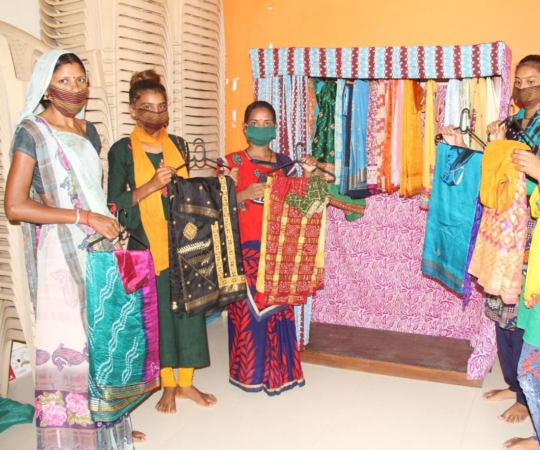 Women holding up colourful clothes at a Gramshree Saree Library