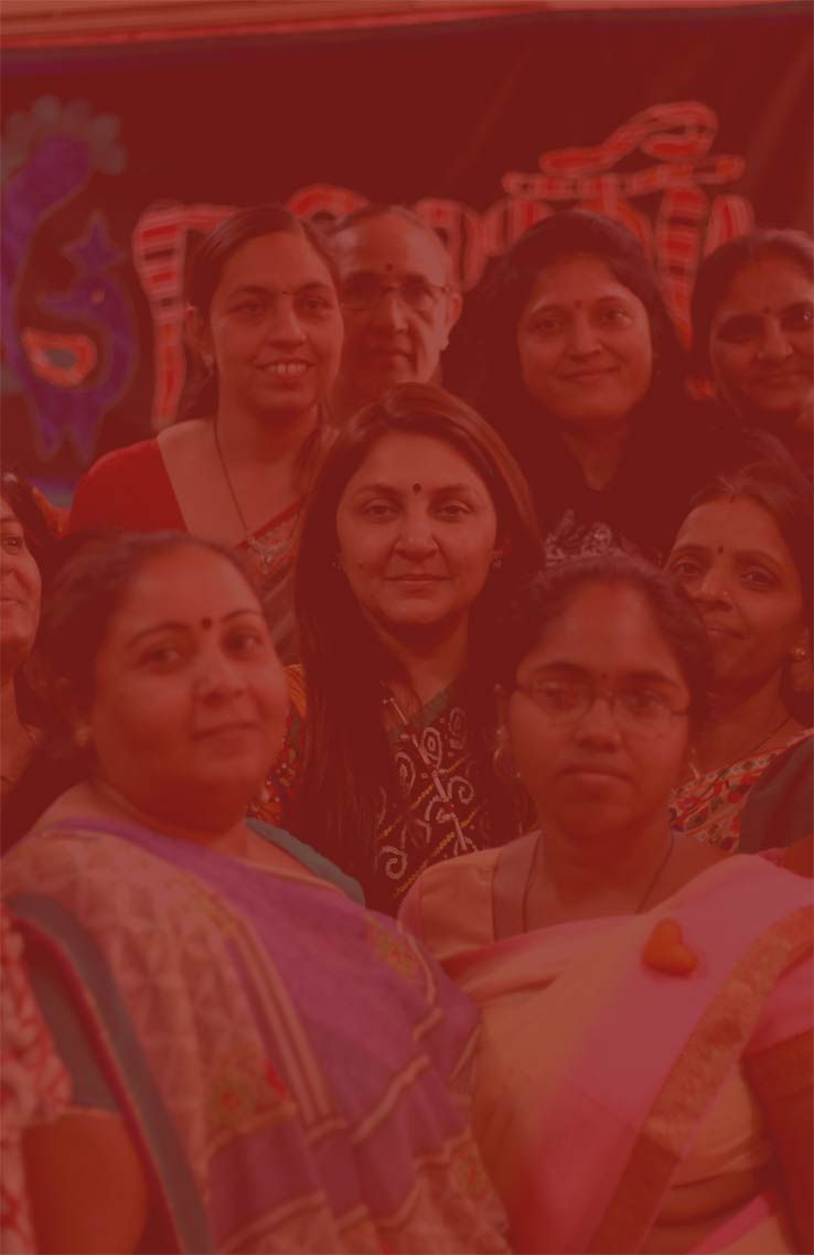 A group of smiling women standing together, shown in a red-tinted photo