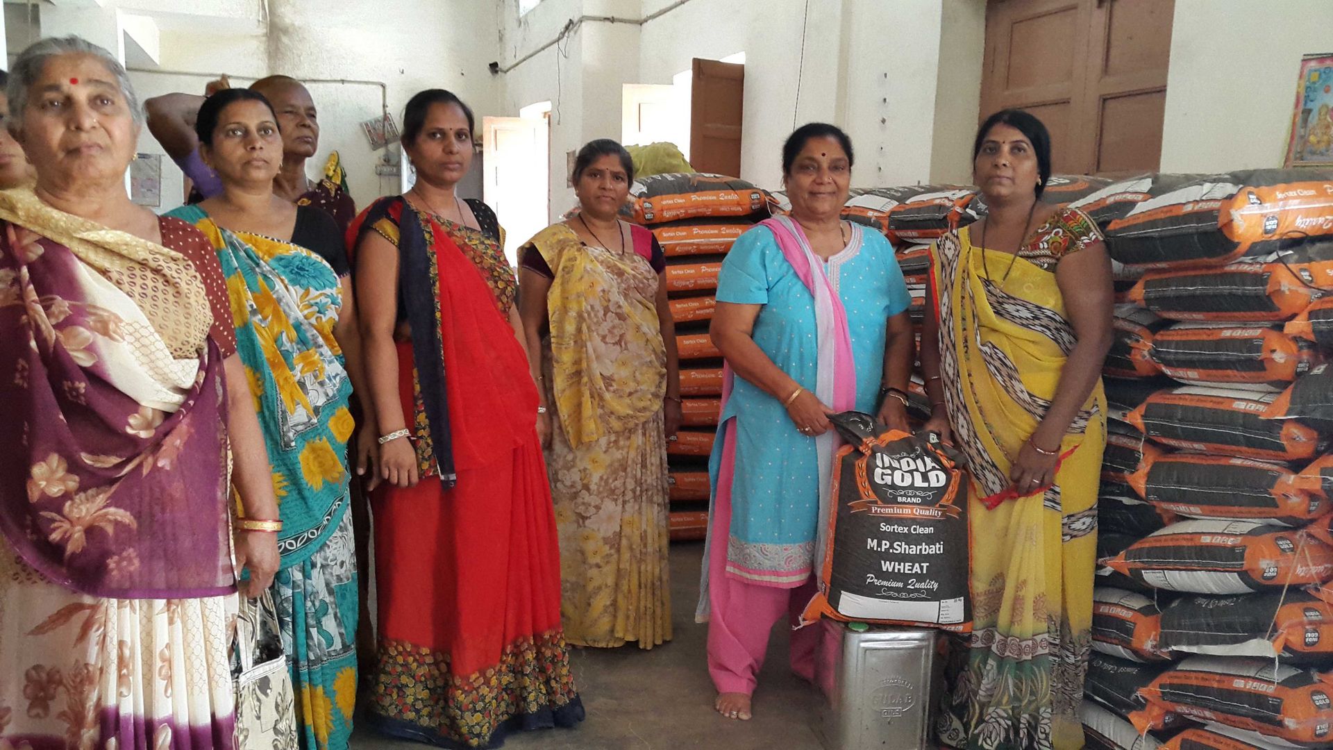 Women of the Gramshree community beside grain sacks from the Food Security Program