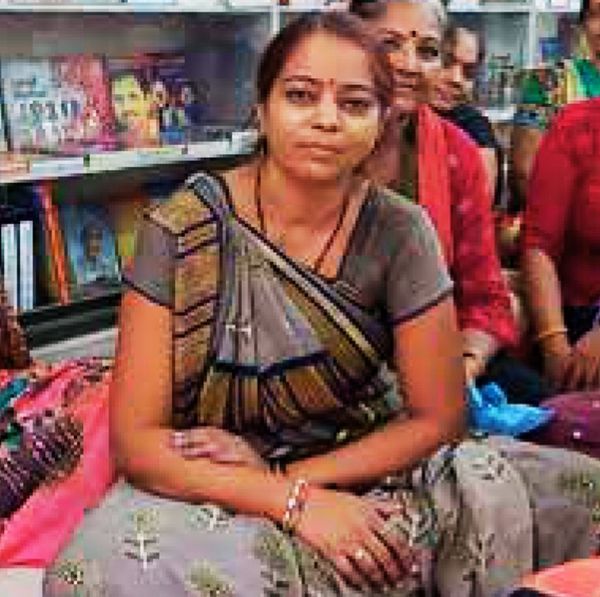 Tejal Rawal in a grey saree, seated with other women in front of bookshelves